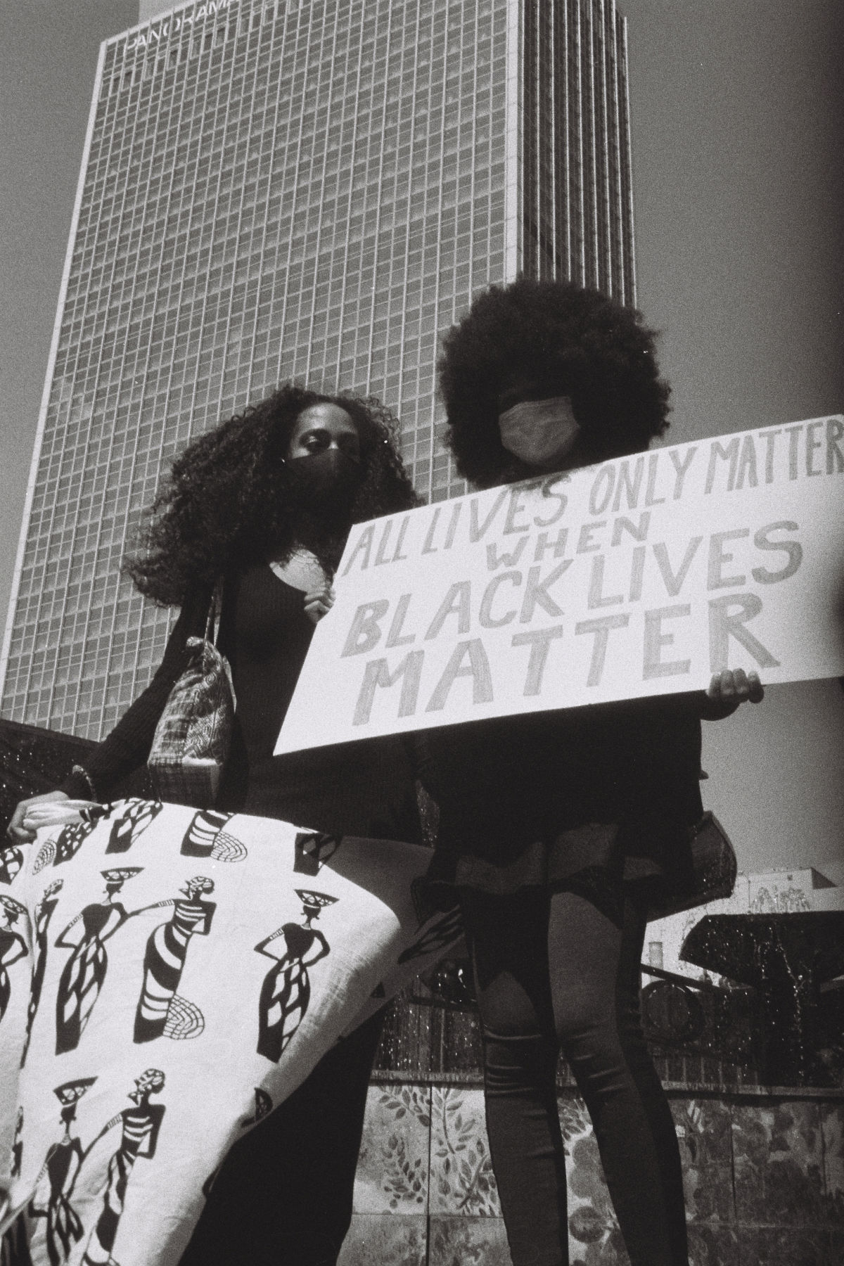 Zwei Schwarze Frauen stehen und halten Protest-Plakate in den H&auml;nden: &raquo;ALL LIVES ONLY MATTER WHEN BLACK LIVES MATTER&laquo;. Im Hintergrund ist ein Hochaus.